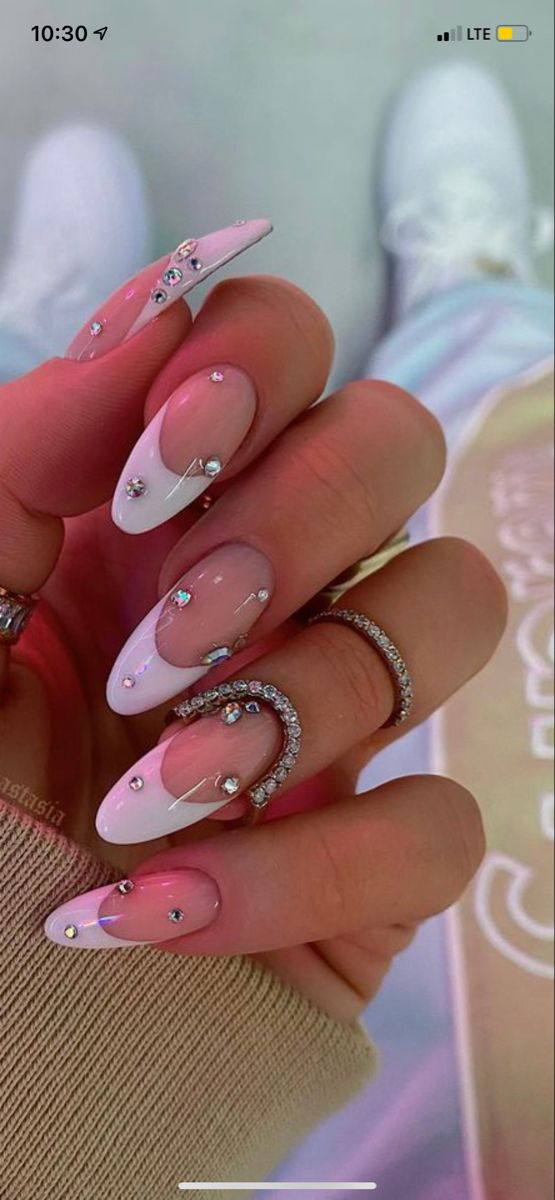 Chic Almond-Shaped Nail Design: Soft Pink and White French Tips with Sparkling Rhinestones.