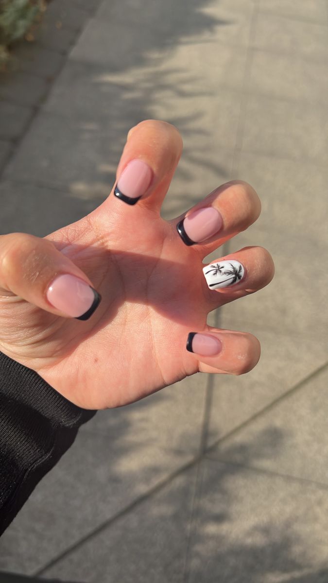 Chic Summer Nail Design: Soft Pink Base with Black French Tips and Palm Tree Accent.