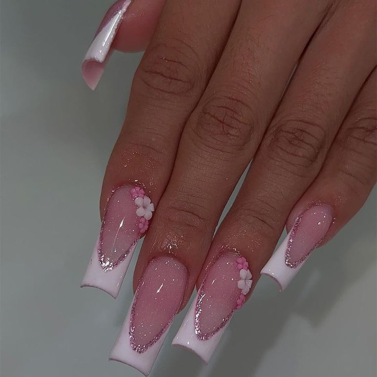 Stunning Stiletto Nail Design: Delicate Pink Ombre with Glitter and Floral Accents.