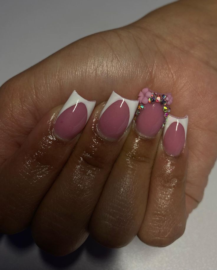 Sophisticated French Manicure with Whimsical Floral Accents and Rhinestones.