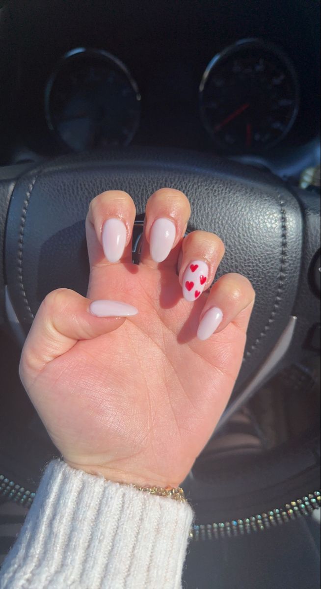 Chic Pastel Pink Almond Nails with Playful Red Heart Accent for Trendy Romance