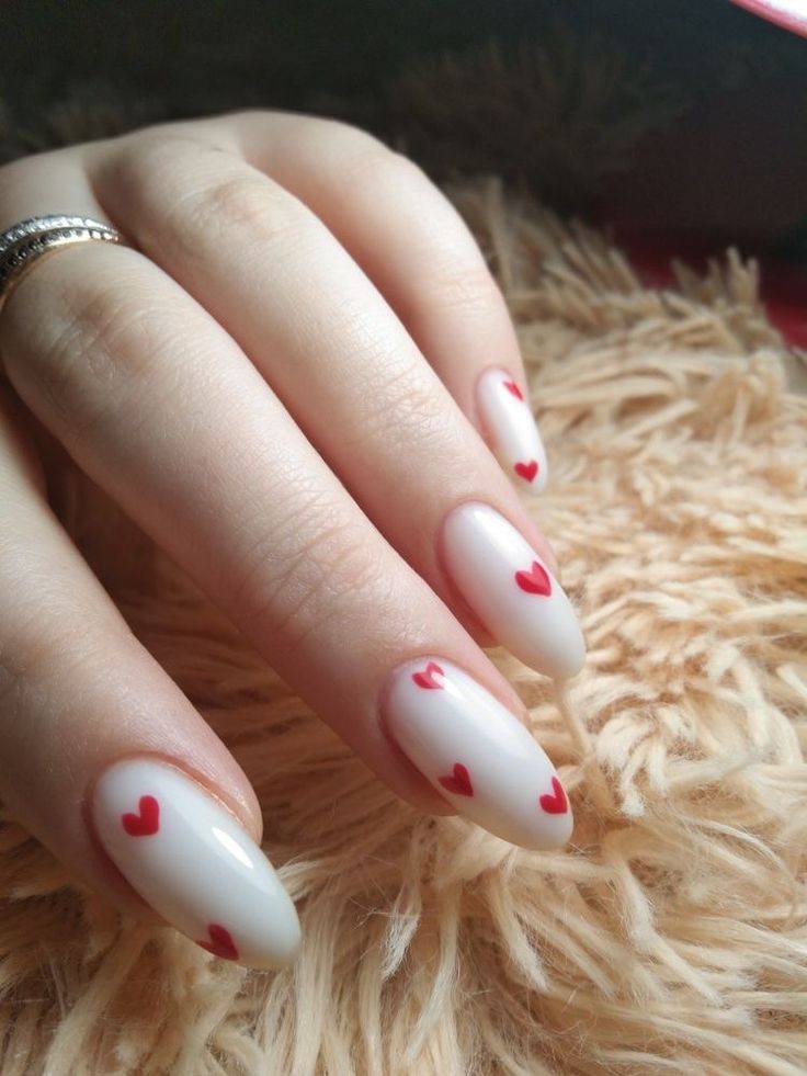 Charming Heart-Themed Nail Design with Playful Red Hearts on Glossy White Background.