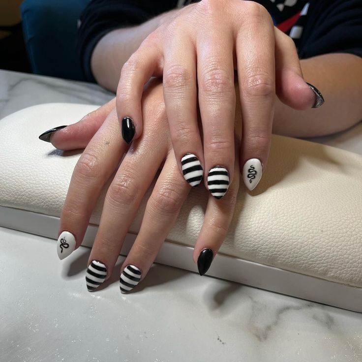 Chic Black and White Nail Art with Bold Stripes and Unique Patterns.