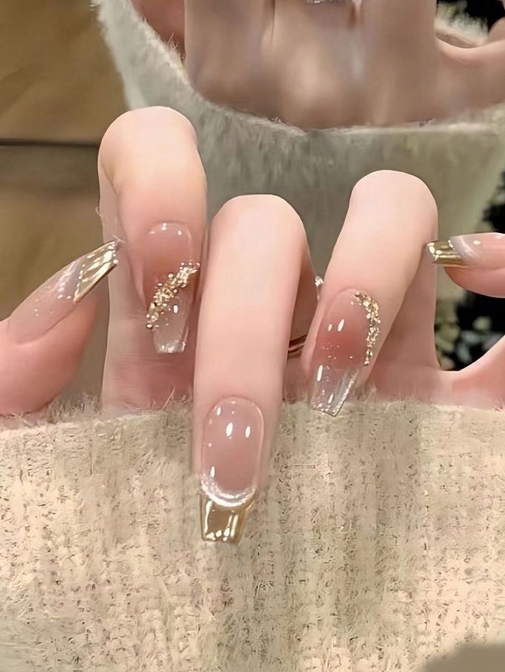 Sophisticated Elegant Nail Design: Clear Base with Shimmering Gold Accents and Glamorous Details.