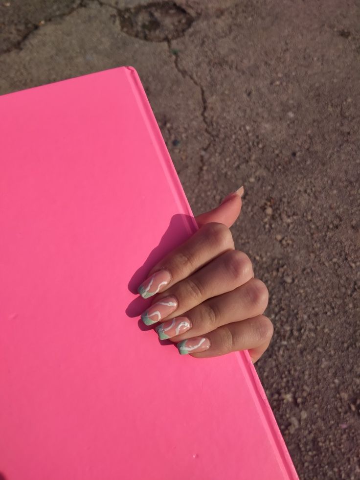 Elegant Pastel Nail Design with Mint Green Tips and Marbled Effect on Vibrant Pink Background.