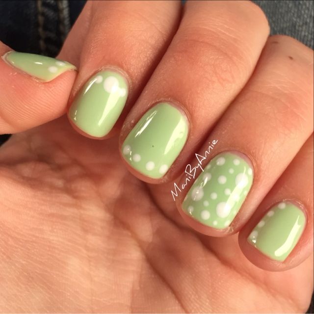 Playful Pastel Green Nail Design with Whimsical White Polka Dots for Spring Manicure.