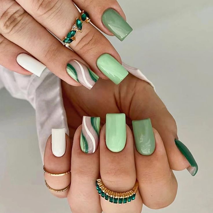 Chic Green Nail Design with Abstract Waves and Elegant Accessories.