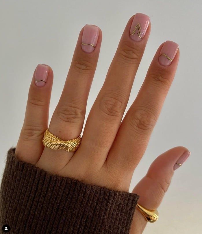 Chic Soft Pink Nail Design with Gold Accents and Minimalist Geometric Lines.