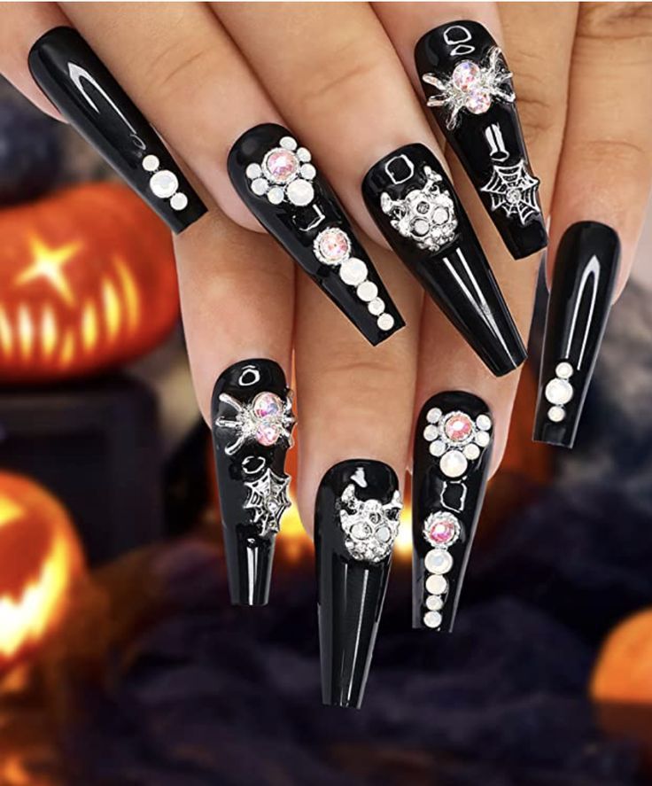 Elegant Gothic Stiletto Nail Design with Intricate Spider Motifs and Gem Accents for Halloween.