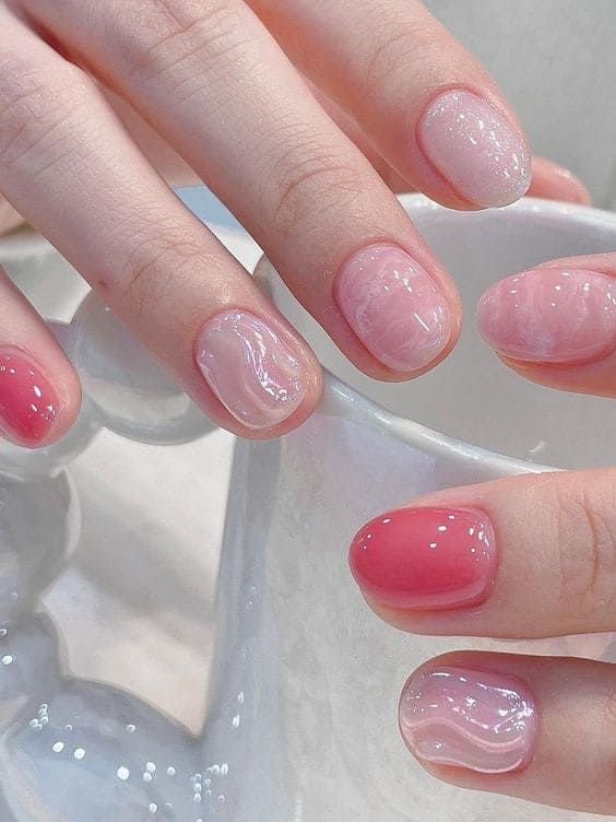 Chic Soft Pink Nail Design with Swirled Textures and Glossy Finishes.