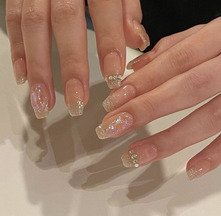 Glamorous Glitter-Infused Nude Nail Design Balances Elegance and Sparkle.