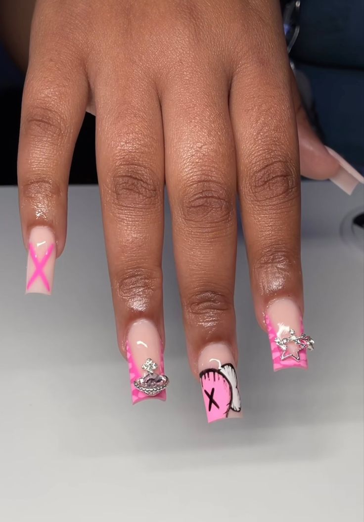 Playful Pink and Nude Nail Design with Intricate Art and Whimsical Embellishments.