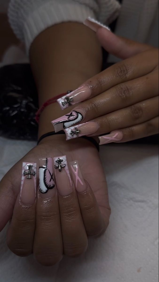 Whimsical Pink and White Acrylic Nail Art with Decorative Patterns and Embellishments.