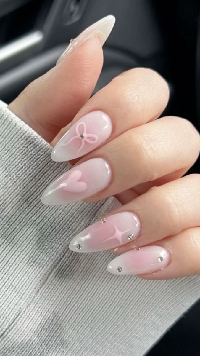 Charming Pink and White Ombre Nail Design with Pointed Tips and Rhinestone Accents.