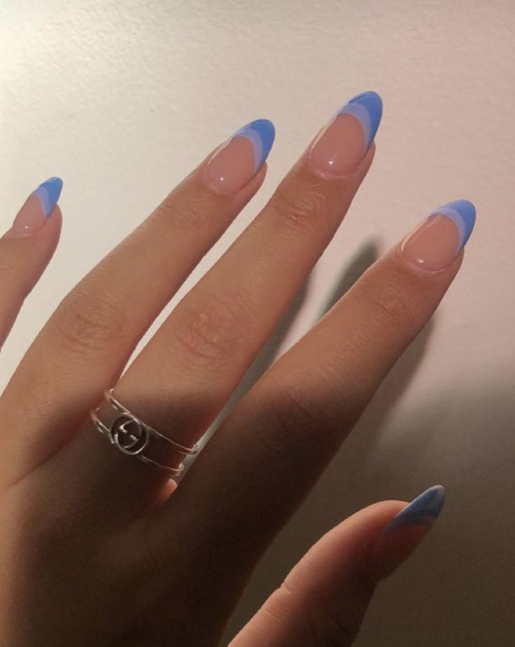 Chic Manicure: Vibrant Blue Tips on Natural Base with Trendy Silver Rings.