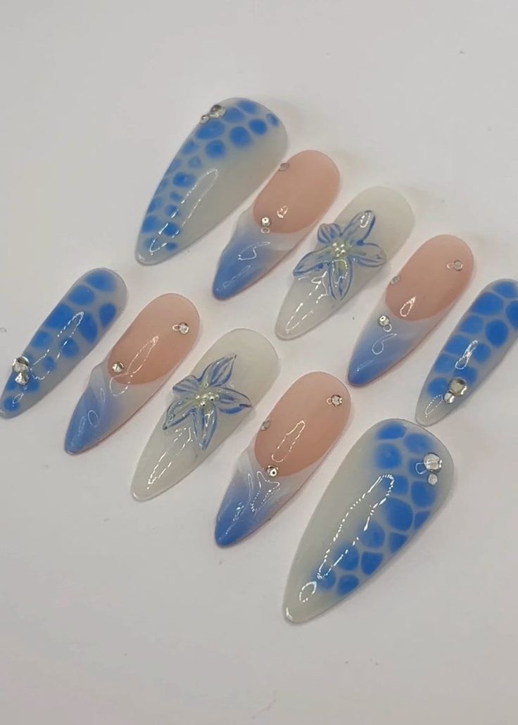 Sophisticated Floral Nail Art with Soft Blue Gradients and Rhinestone Accents.