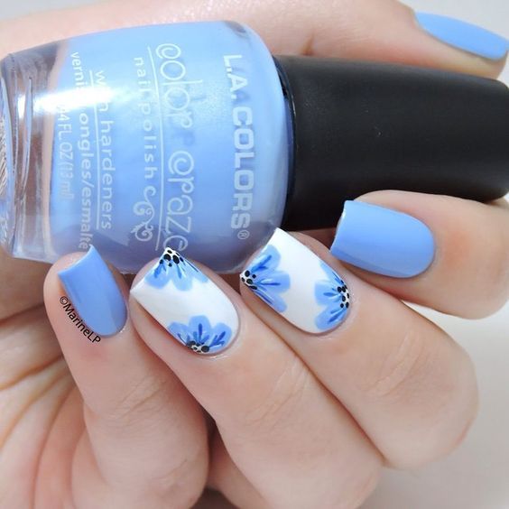 Elegant Blue Nail Design with Floral Accents for a Playful Look