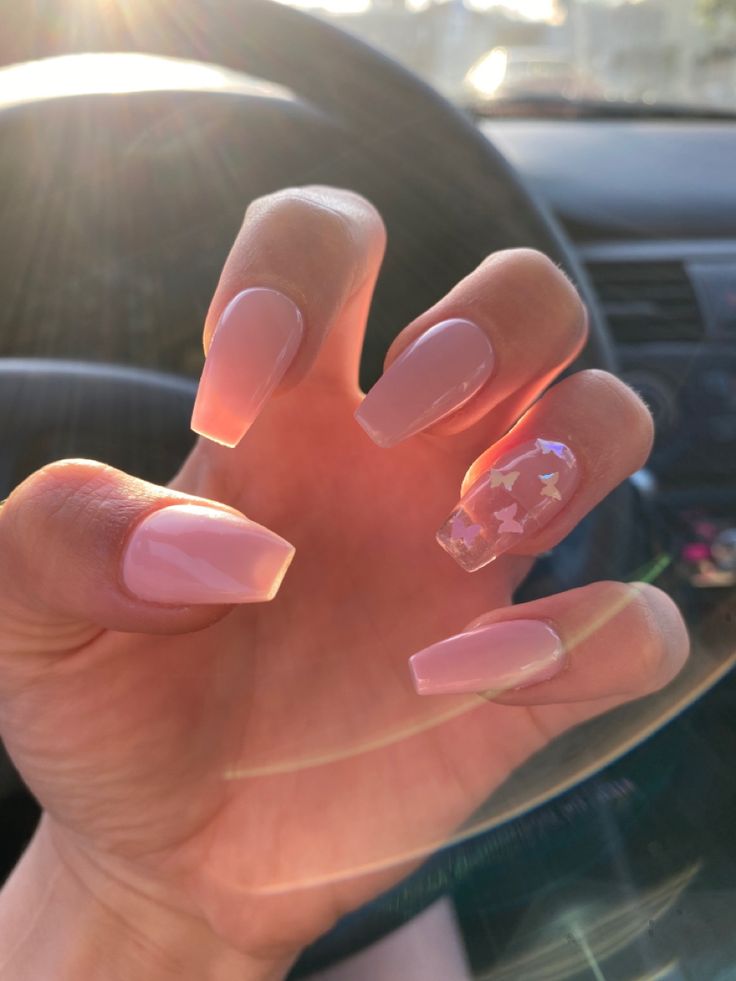 Chic Soft Pink Nail Design with Whimsical Accent Details.