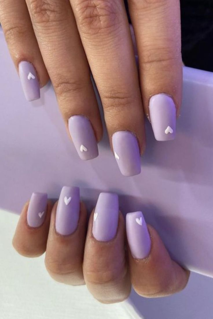 Charming Lavender Matte Nails with Whimsical Heart Accents for a Stylish Manicure.