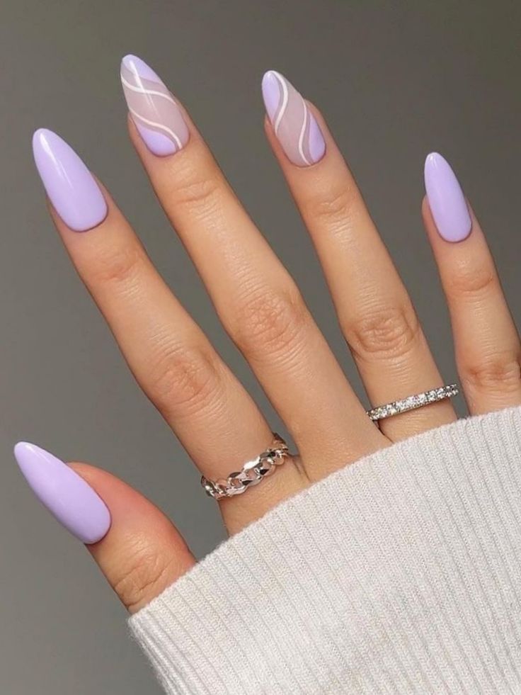 Chic Lavender Ombre Almond Nails with Elegant White Swirl Accents and Silver Ring Complementation.