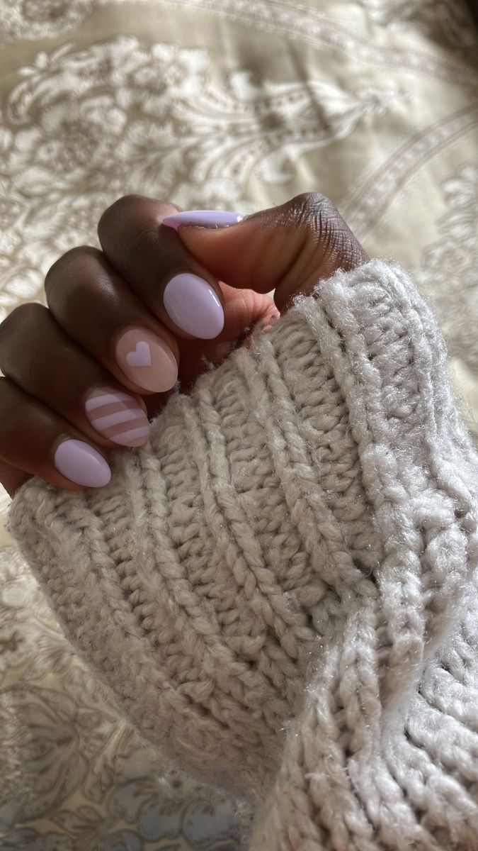 Charming Pastel Lavender Nail Design with Playful Hearts and Stripes Perfectly Complemented by a Cozy Knit Sweater.