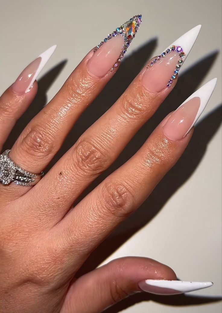 Elegant Stiletto Nail Design with Nude, White, and Gemstone Accents.