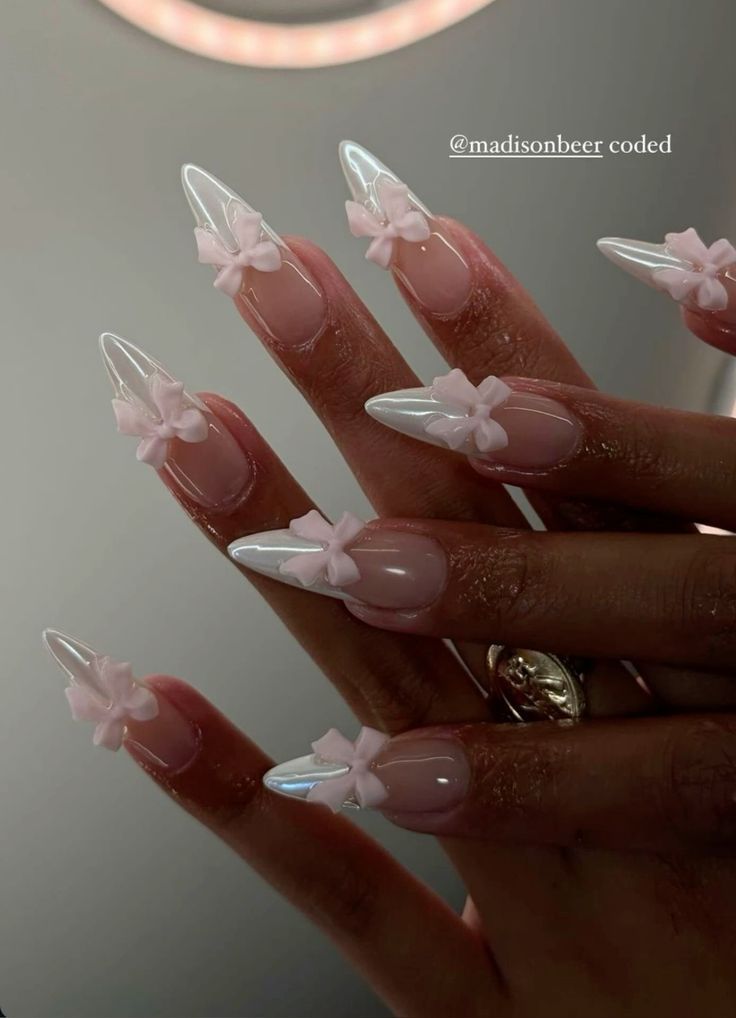 Chic Stiletto Nails with Iridescent Finish and Charming Pink Bow Accents.