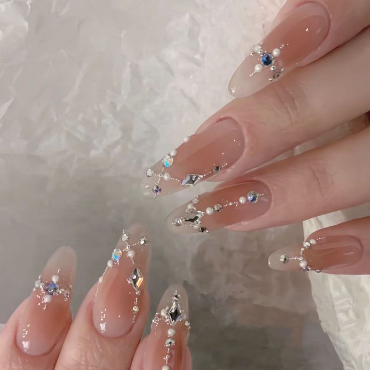 Chic Nude Ombre Nail Design Adorned with Gems and Pearls