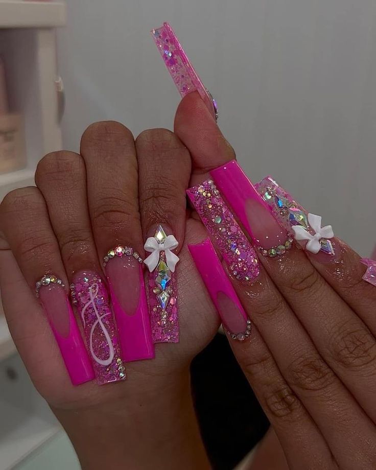 Striking Vibrant Pink Nails with Intricate Embellishments and Bold Acrylic Design.