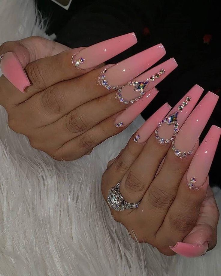 Luxurious Long Pink Nails with Glossy Finish and Sparkling Rhinestone Accents.