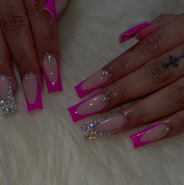 Chic Nail Design: Bold Pink Tips with Elegant Nude Bases and Sparkling Rhinestones.