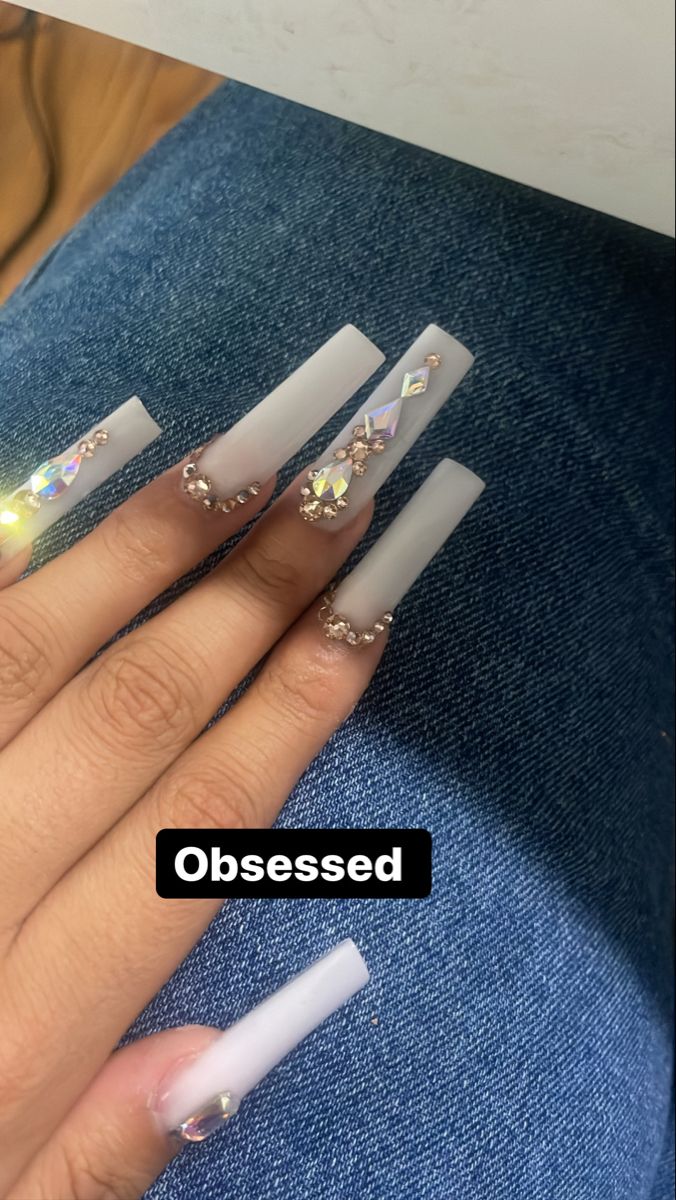 Elegant Ombre Long Nails with Glamorous Rhinestones and Unique Designs.