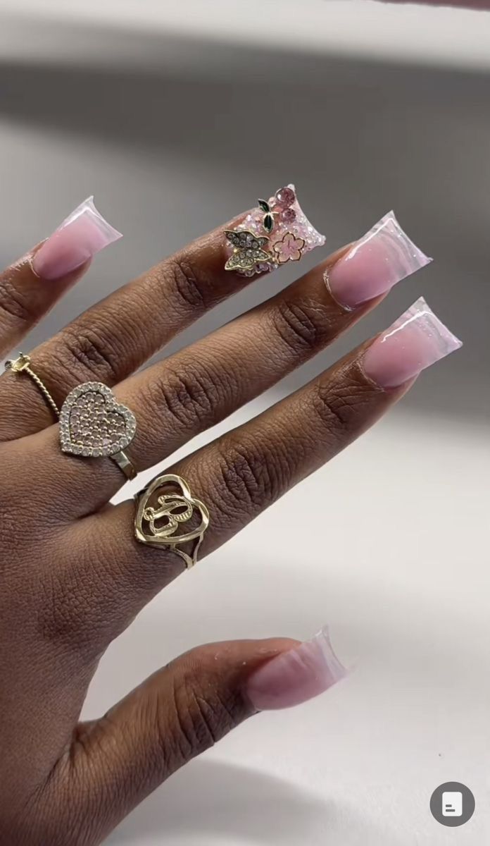 Sophisticated Nail Design: Soft Pink Tones with Clear Tips and Floral Accents.