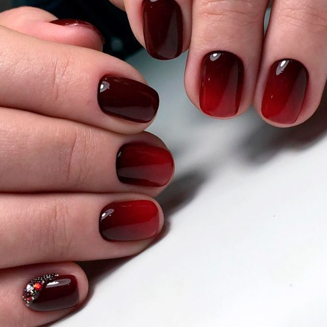 Sophisticated Crimson Ombre Nails with Sparkling Embellishment.