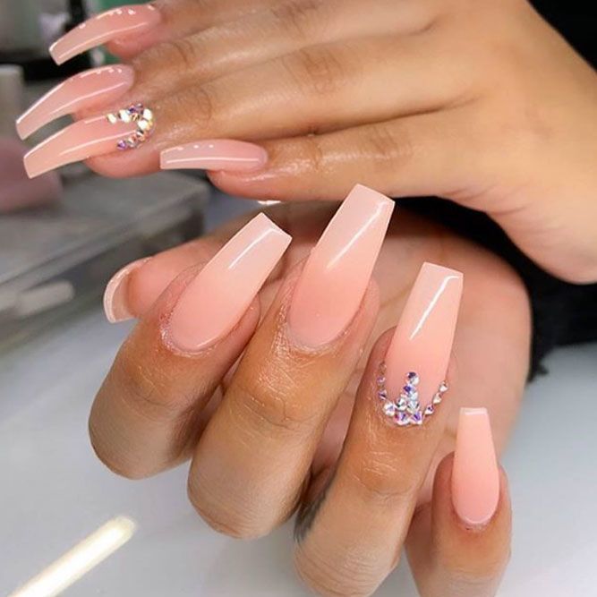 Sophisticated Elegant Nude Acrylic Nails with Glossy Finish and Glamorous Embellishments.