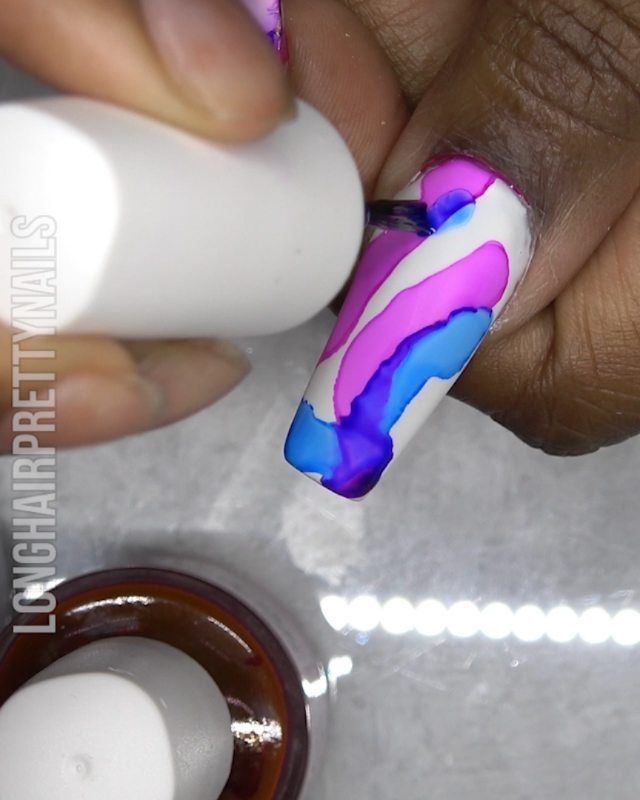 Bold Swirl Pattern Nail Art: A Playful Contrast of Pink and Blue on White.