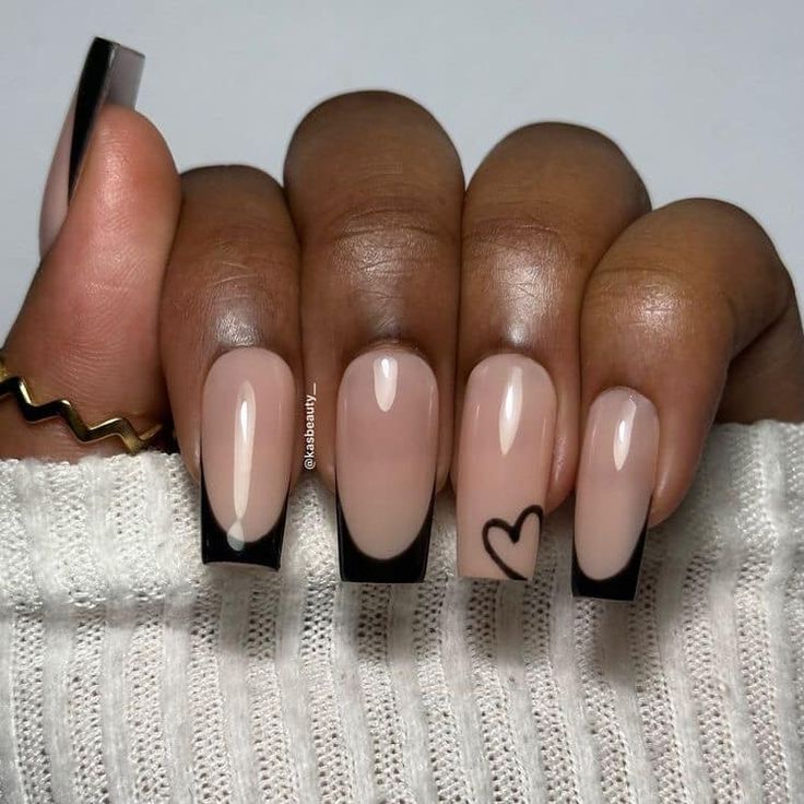 Chic Versatile Nail Design: Soft Nude Base with Bold Black Tips and Charming Heart Details