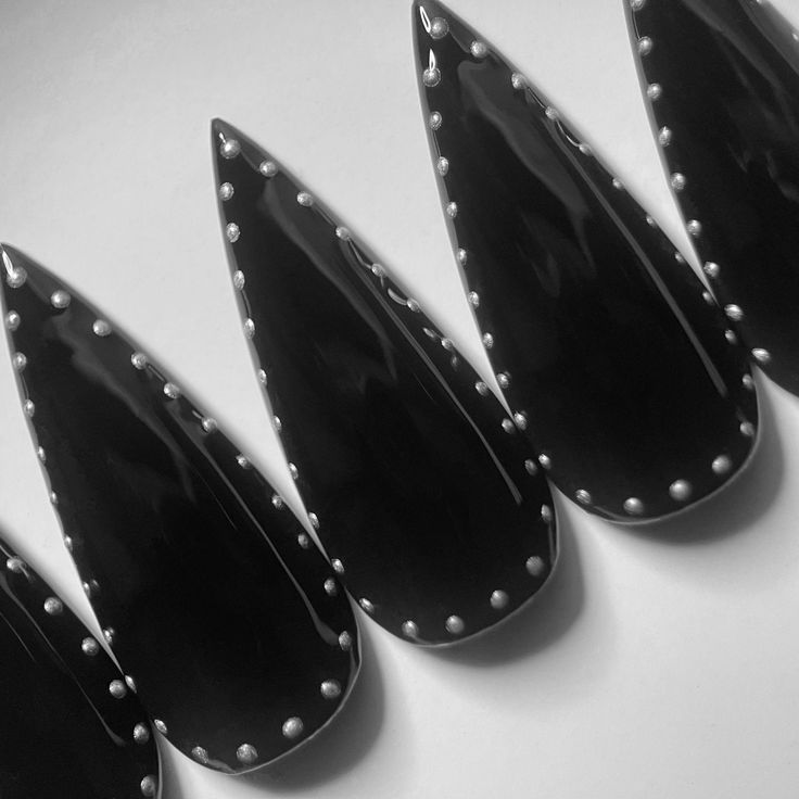 Bold Stiletto-Shaped Black Nails with Silver Studs: A Sophisticated, Rock-Inspired Statement Look.