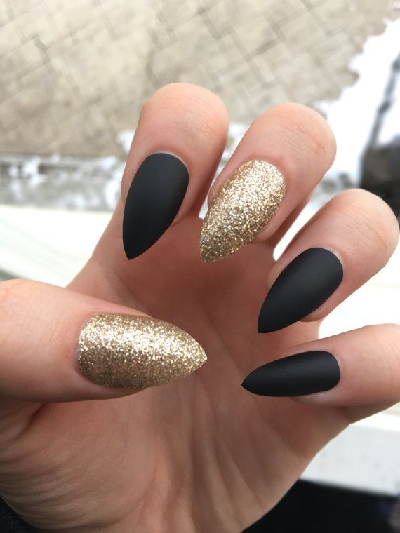 Sophisticated Almond-Shaped Nail Design: Matte Black Meets Glittering Gold.