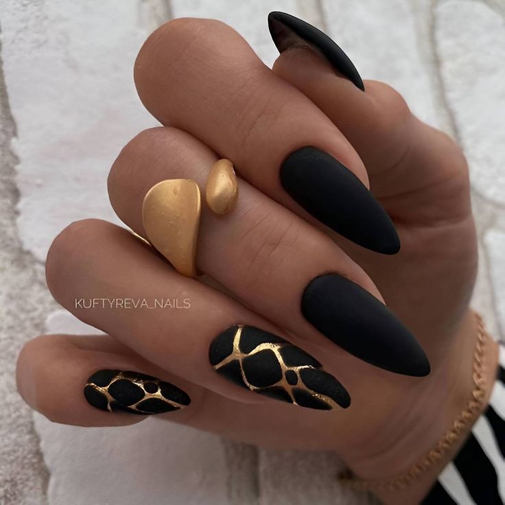 Striking Elegant Black Matte Nails with Glossy Gold Detailing and Sophisticated Stiletto Shape.