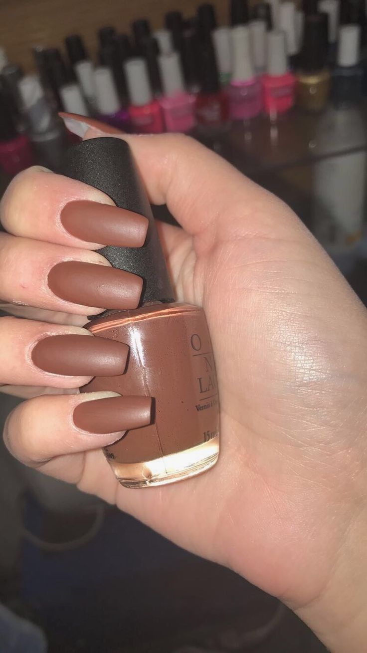 Chic Almond-Shaped Matte Brown Manicure with Playful Glossy Accents.