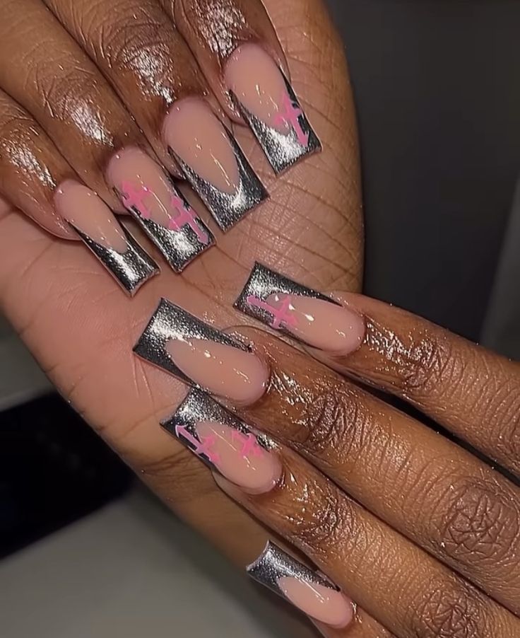 Chic Nail Design with Nude and Metallic Elements, Sharp Tips, and Playful Pink Accents.