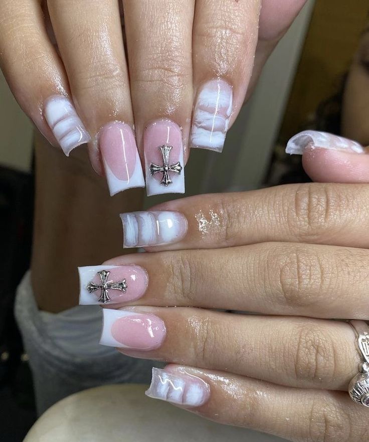 Elegant Soft Pink and White Nail Design with Marble Effects and Silver Cross Embellishments