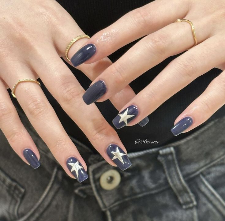 Chic Deep Navy Nail Design with Glossy Finish and Golden Star Accents.