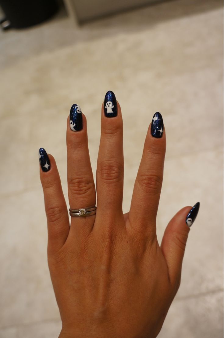 Whimsical Dark Blue Nail Design with Ghost and Star Motifs for Festive Elegance.