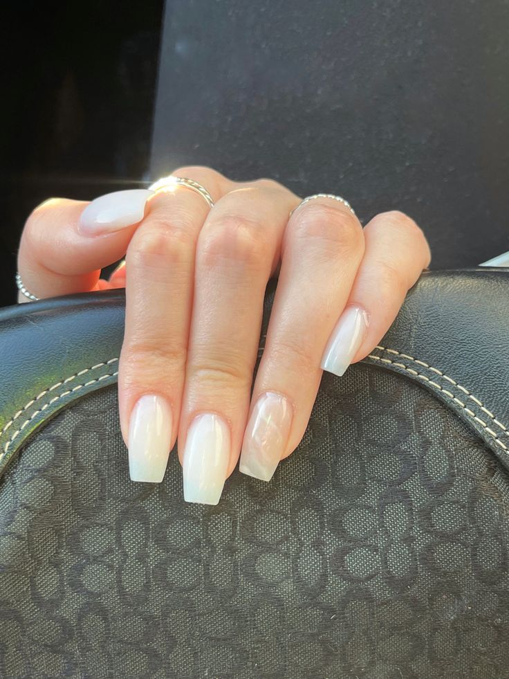 Sophisticated Soft White Square Nails with Glossy Finish and Unique Transparency Twist.