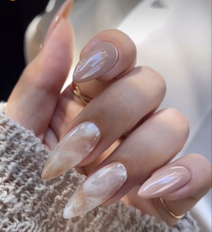 Chic Almond-Shaped Nails: Elegant Beige and Marble Design with Glossy Finish.