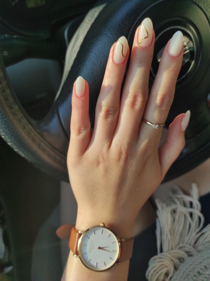 Chic Almond-Shaped Nails with Soft Nude Base, Delicate White Tips, and Subtle Gold Accents.