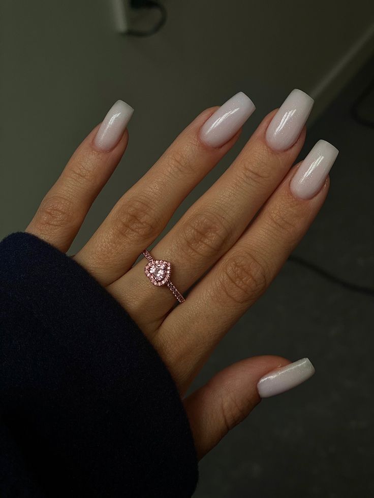 Sophisticated Glossy Nude Nail Design with Long Square Shape and Heart-Shaped Ring Accents.