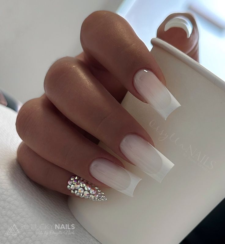 Sophisticated French Manicure with Ombre and Rhinestone Accent.